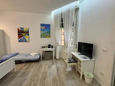 a bedroom with a bed and a desk and a television at Malila's-Cipitelli Trevi in Rome