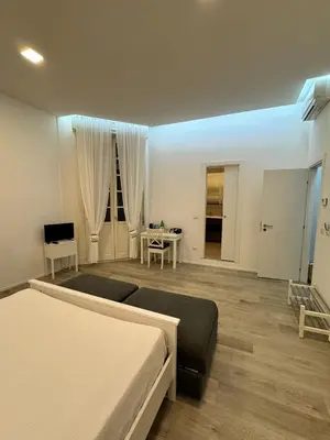 a bedroom with two beds and a desk in it at Malila's-Cipitelli Trevi in Rome