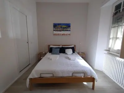 a bedroom with a large bed in a white room at Malila's-Cipitelli San Pietro in Rome