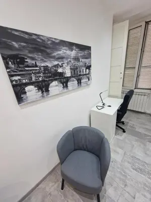a room with a chair and a desk and a painting at Relux Pretoria Rooms in Rome