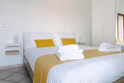a bedroom with a white bed with towels on it at Rooftop Apartment Quadraro in Rome