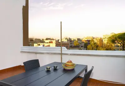 a table on a balcony with a view of a city at Rooftop Apartment Quadraro in Rome