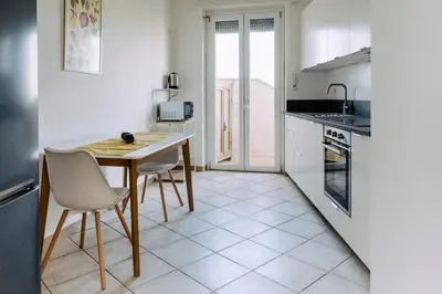 a kitchen with a table and chairs and a kitchen with white cabinets at Rooftop Apartment Quadraro in Rome