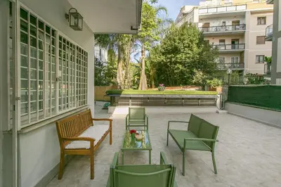 a patio with chairs and tables and a building at Arbia Stay in Rome