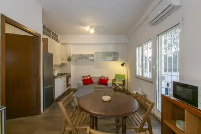 a small living room with a table and a kitchen at Arbia Stay in Rome