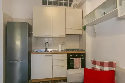 a kitchen with white cabinets and a stainless steel refrigerator at Arbia Stay in Rome