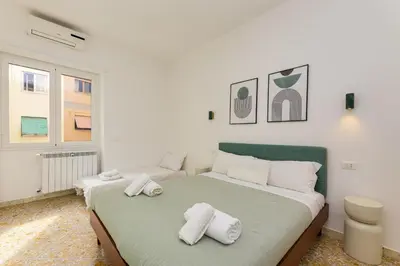 a white bedroom with a bed with towels on it at NiMa Holiday 49 in Rome