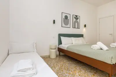 two beds in a bedroom with white walls at NiMa Holiday 49 in Rome