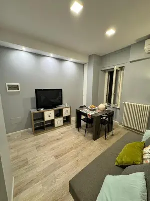 a living room with a television and a dining room table at Malila's - Cipitelli Spagna in Rome