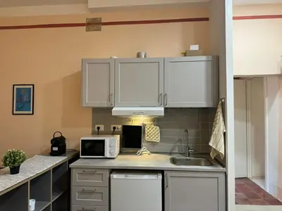 a kitchen with white cabinets and a microwave at Le Due Torri in Rione Monti in Rome