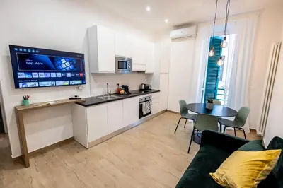 a dining room with a black table and chairs at Re di Roma Ela Apartment in Rome
