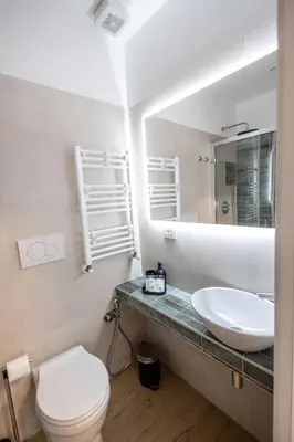 a bathroom with a sink and a toilet and a mirror at Re di Roma Ela Apartment in Rome