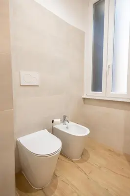 a white bathroom with a toilet and a sink at Re di Roma Ela Apartment in Rome