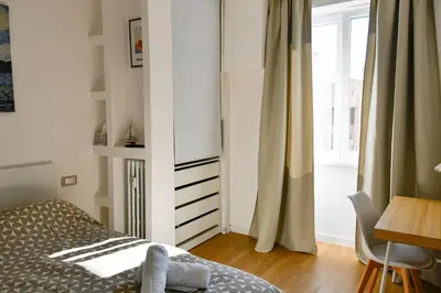 a bedroom with a bed and a desk and a window at Dima Home Cute Flat in Rome in Rome