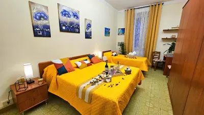 a bedroom with two beds with yellow bedspreads at Casa Simpatia Roma Vaticano in Rome