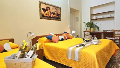 two beds in a room with yellow sheets at Casa Simpatia Roma Vaticano in Rome