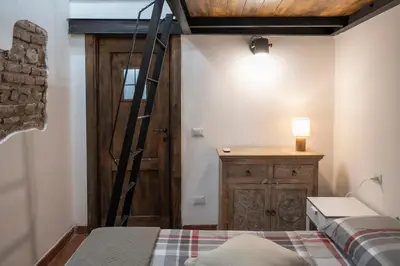a room with a bed and a ladder next to a door at Home Domus Capocci - Rione Monti in Rome