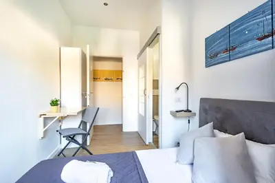 a bedroom with a bed and a desk and a chair at La casa di Elba in Rome