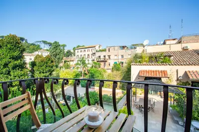 a table on a balcony with a view of a city at La casa di Elba in Rome