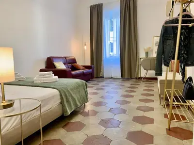 a bedroom with a bed and a couch and a chair at Non prenotate in Rome