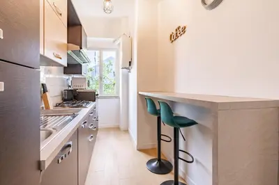 a kitchen with a counter and stools in it at Metro A 3 fermate da San Pietro - 2 Camere Luminoso - Domus Valeria in Rome