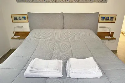 a bed with two white towels on top of it at La maisonette romana in Rome