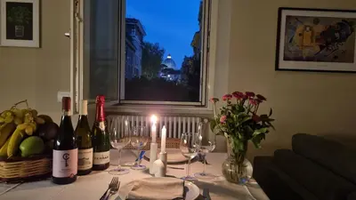 a table with wine bottles and glasses and candles on it at Maggie's House in Rome