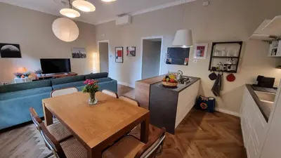 a living room with a table and a blue couch at Maggie's House in Rome