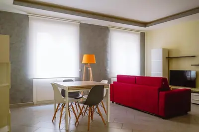 a living room with a red couch and a table and chairs at Domus Gianicolensis in Rome