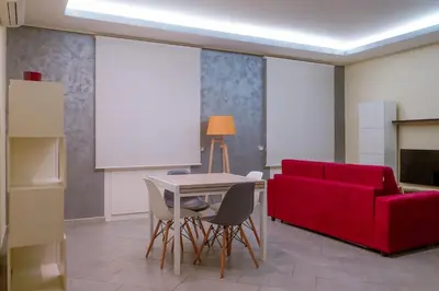 a living room with a red couch and a table and chairs at Domus Gianicolensis in Rome