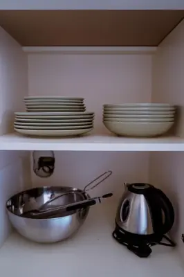 a kitchen shelf with plates and a pan and dishes at Domus Gianicolensis in Rome