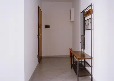 a hallway with a mirror and a wooden chair at Domus Gianicolensis in Rome
