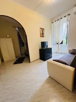 a bedroom with a couch and a tv in a room at Casa vacanza La Rosa di Oscar - Testaccio in Rome
