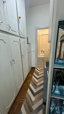 a small kitchen with white cabinets and a bathroom at Trastevere Welcome Home Superior in Rome