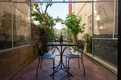 a table with two chairs and a bottle of wine at Roma centro pochi minuti - Appartamento con giardino privato in Rome