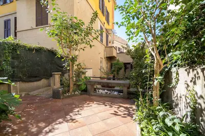 a bench sitting in the courtyard of a building at Roma centro pochi minuti - Appartamento con giardino privato in Rome