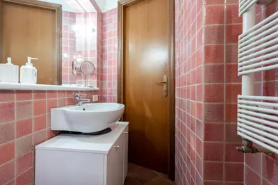 a bathroom with a sink and a toilet with pink tiles at Roma centro pochi minuti - Appartamento con giardino privato in Rome