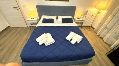 a large blue bed in a room with two lamps at Trastevere Welcome Home Deluxe 2 in Rome