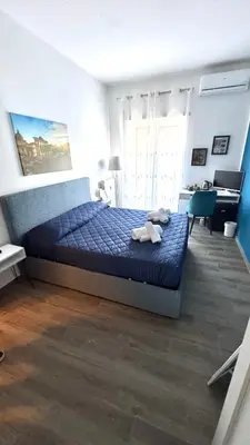 a bedroom with a bed with a blue comforter and a desk at Trastevere Welcome Home Deluxe 2 in Rome
