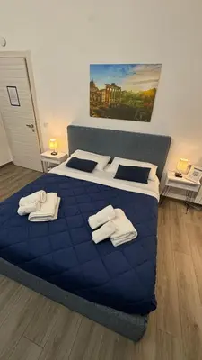 a bedroom with a blue bed with towels on it at Trastevere Welcome Home Deluxe 2 in Rome