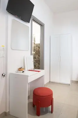 a white desk with a red stool and a window at Gmm in Rome