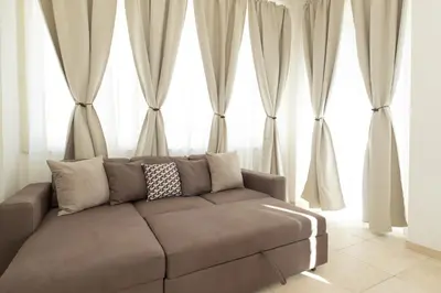 a couch in a living room with large windows at Casa Sole in Rome