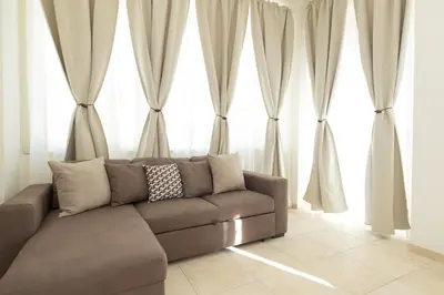 a living room with a couch in front of large windows at Casa Sole in Rome
