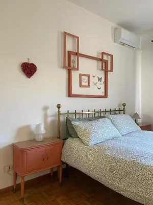 a bedroom with a bed and a table and a heart on the wall at Interno33 Appartamento accogliente e moderno vicino Stazione Tiburtina in Rome