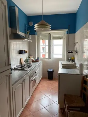 a kitchen with blue walls and a stove top oven at Interno33 Appartamento accogliente e moderno vicino Stazione Tiburtina in Rome