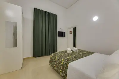 a hotel room with a bed and a green curtain at Via Veneto - Dolce Vita Alcova in Rome