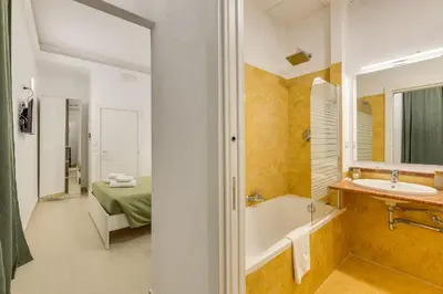 a bathroom with a tub and a sink and a bed at Via Veneto - Dolce Vita Alcova in Rome