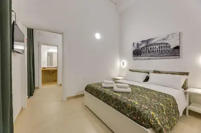 a white bedroom with a bed with two towels on it at Via Veneto - Dolce Vita Alcova in Rome