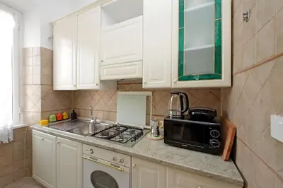 a kitchen with white cabinets and a sink and a microwave at 4BNB - Queen Mary Vatican Home in Rome