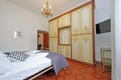 a bedroom with a bed and some wooden cabinets at 4BNB - Queen Mary Vatican Home in Rome
